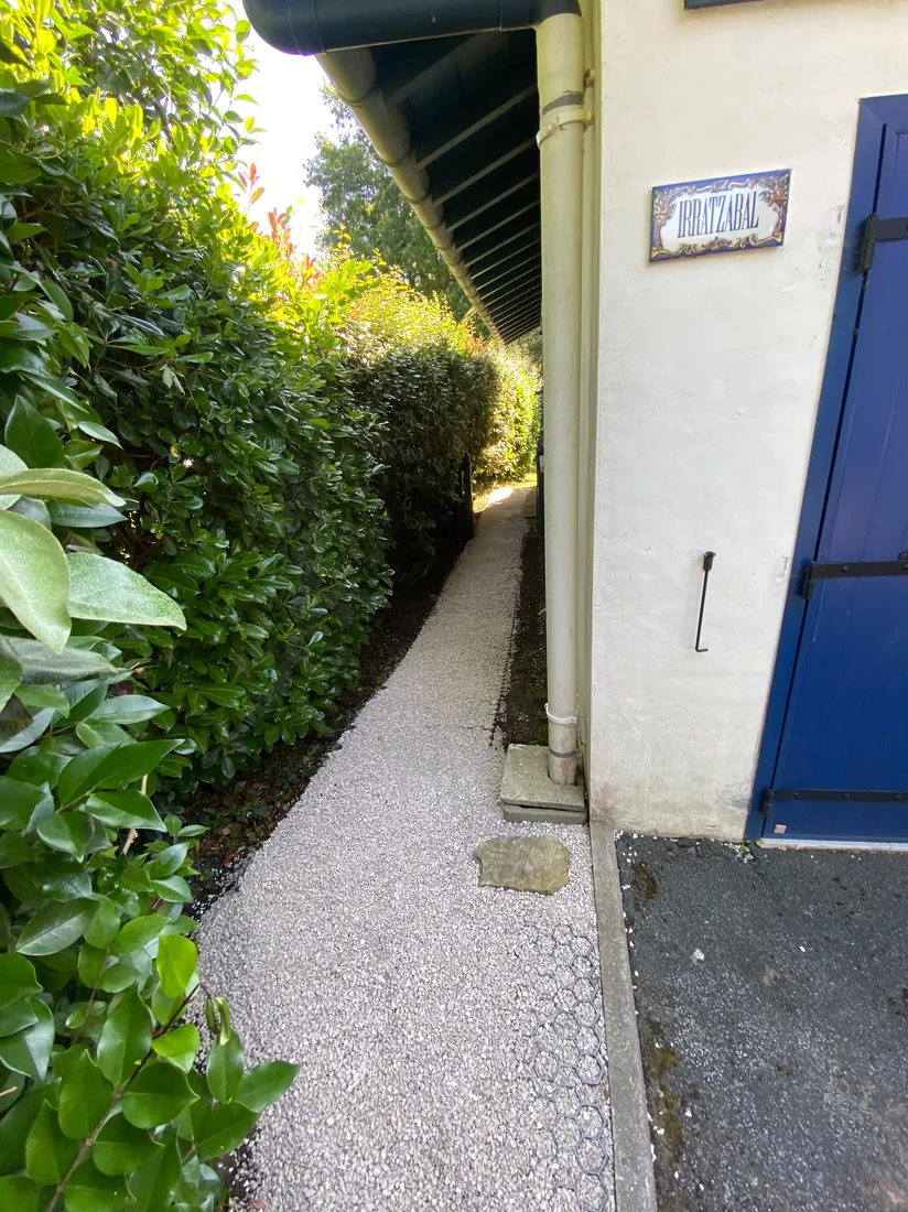 Allée paysagère aménagée en gravier drainant et pavés de bordure par notre équipe
